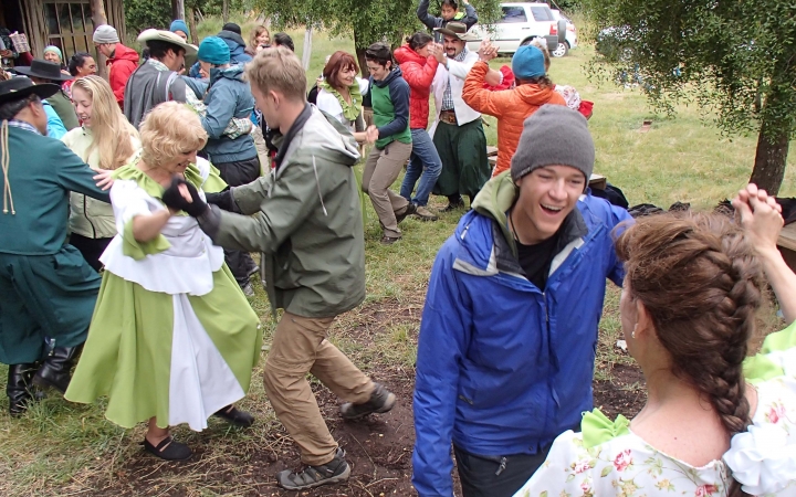 A group of people dance outdoors.